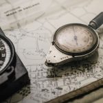 Navigation - Shallow Focus Photography of Black and Silver Compasses on Top of Map