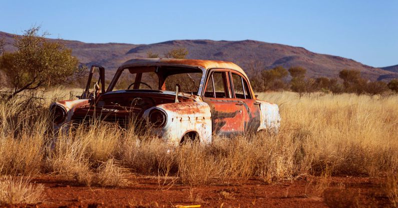 Corrosion - Photo of Corroded Vintage White and Red Sedan on Brown Grass